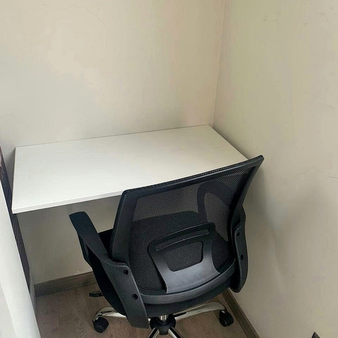 Mesa blanca de 80 por 40 centímetros con una silla de oficina